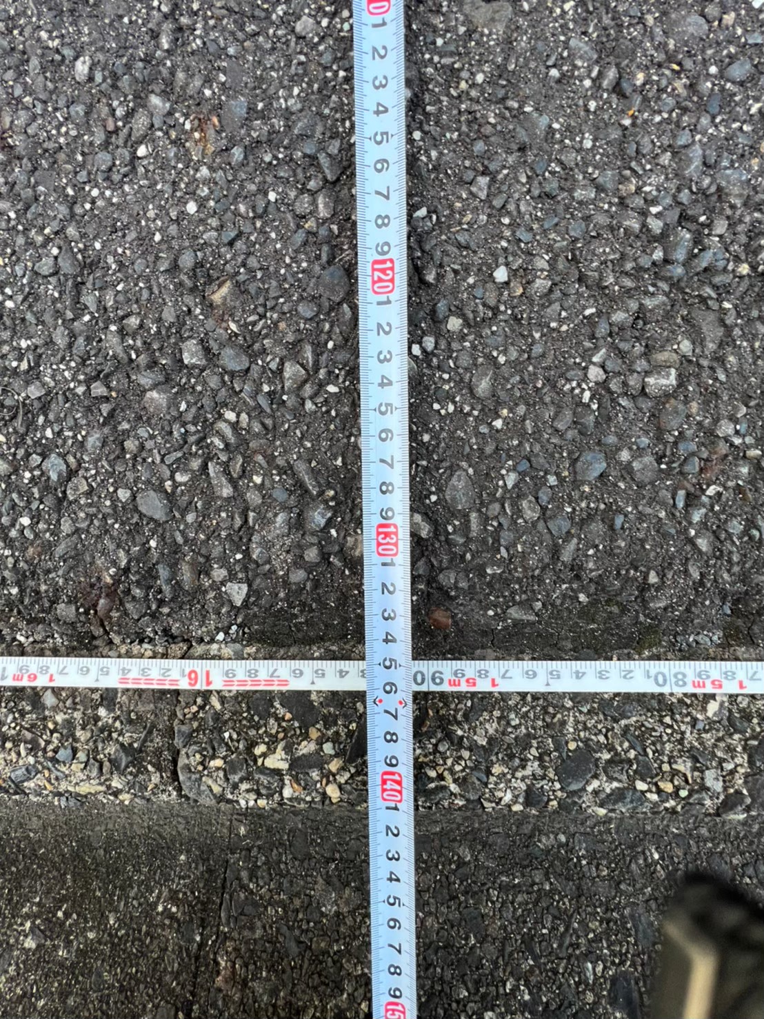 駐車区画を2本のスケールで正確に計測している写真